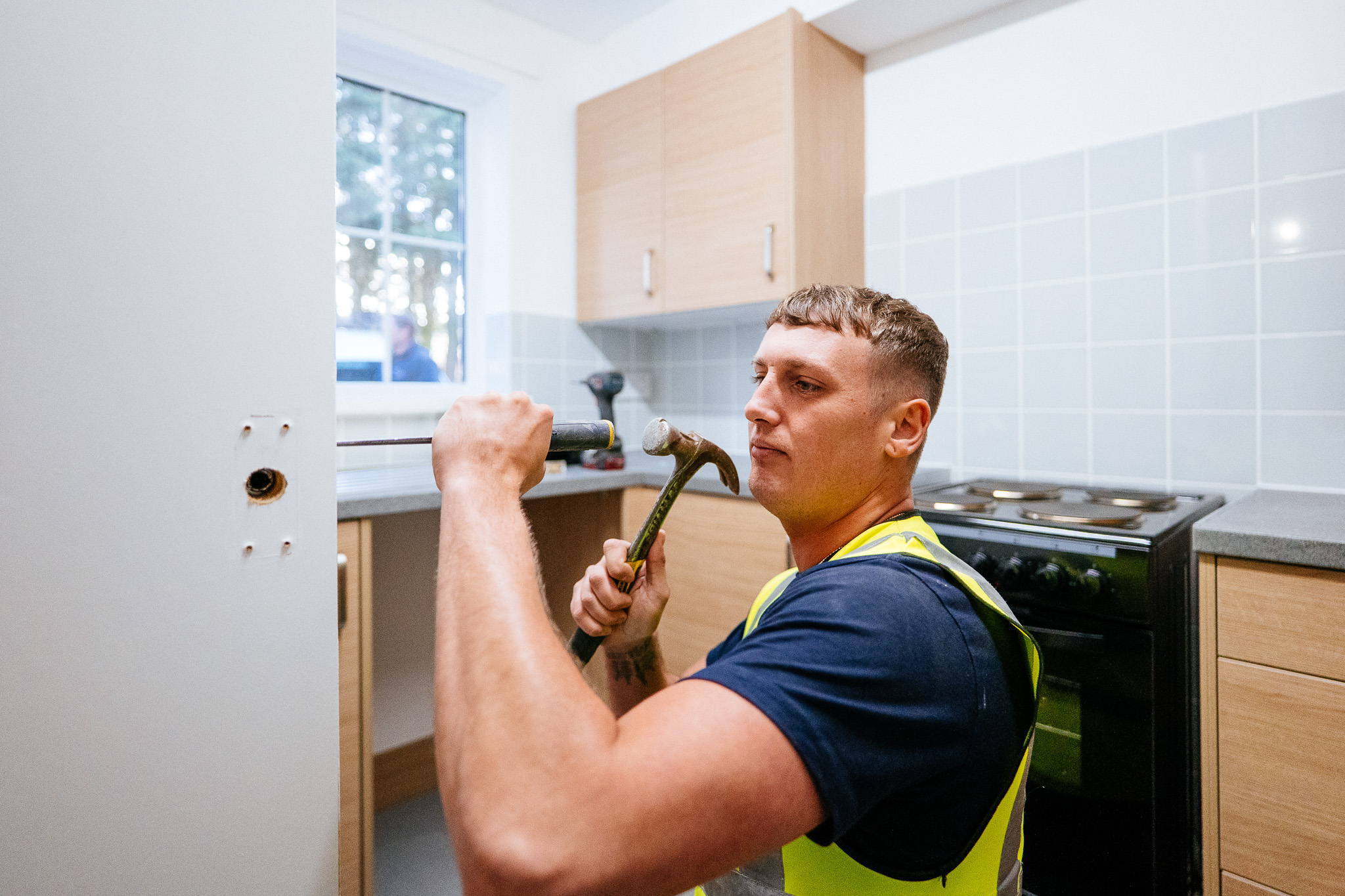 Progress Housing Group repairs team fixing a kitchen door in a tenant’s home