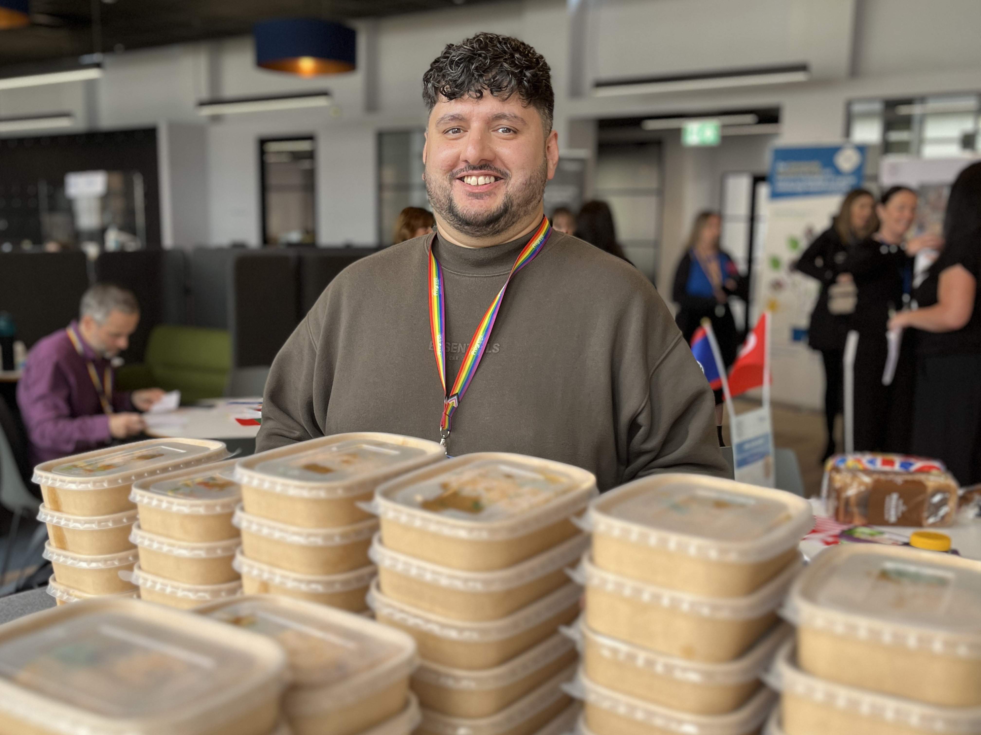A Progress team member with boxes of food at a community support initiative.