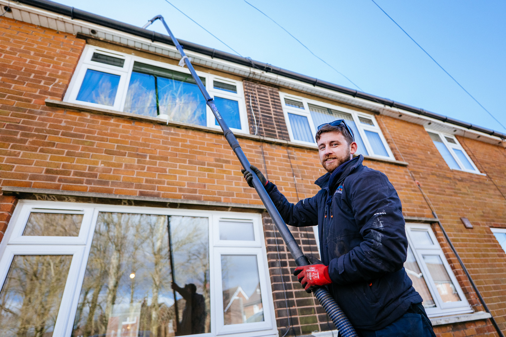 A Progress team member clearing leaves from guttering as part of property maintenance.