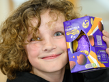 Image of child smiling next to his easter egg