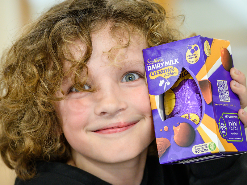 Image of child smiling next to his easter egg