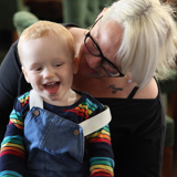 "tenant holding little boy, who is smiling"