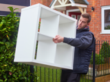 Colleague carrying a 4 square Kallax unit outside 