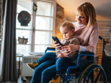 Image of lady in wheelchair with child on her lap