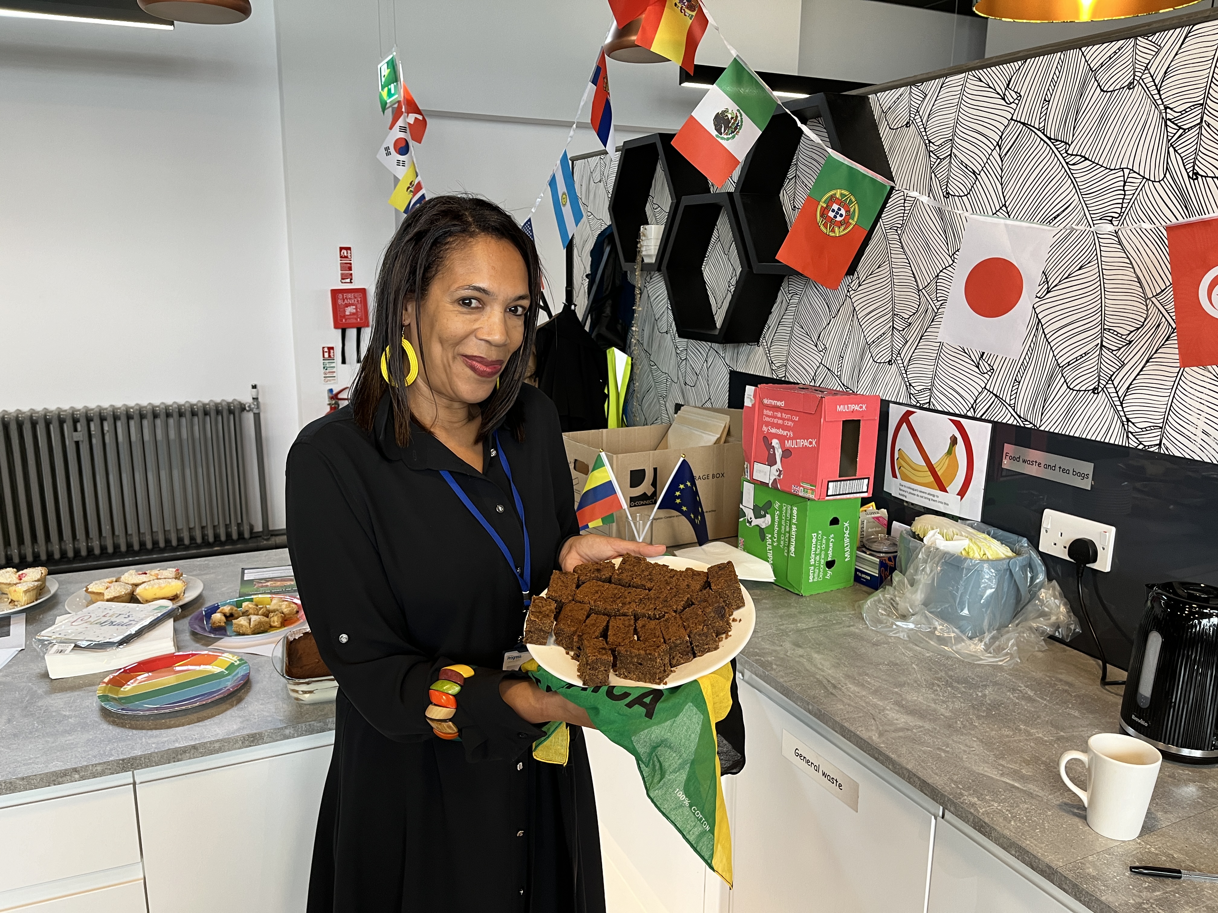 A woman holding a plate of cake at a Progress Housing Group community food event.
