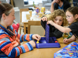 Image of lady and kids playing connect 4