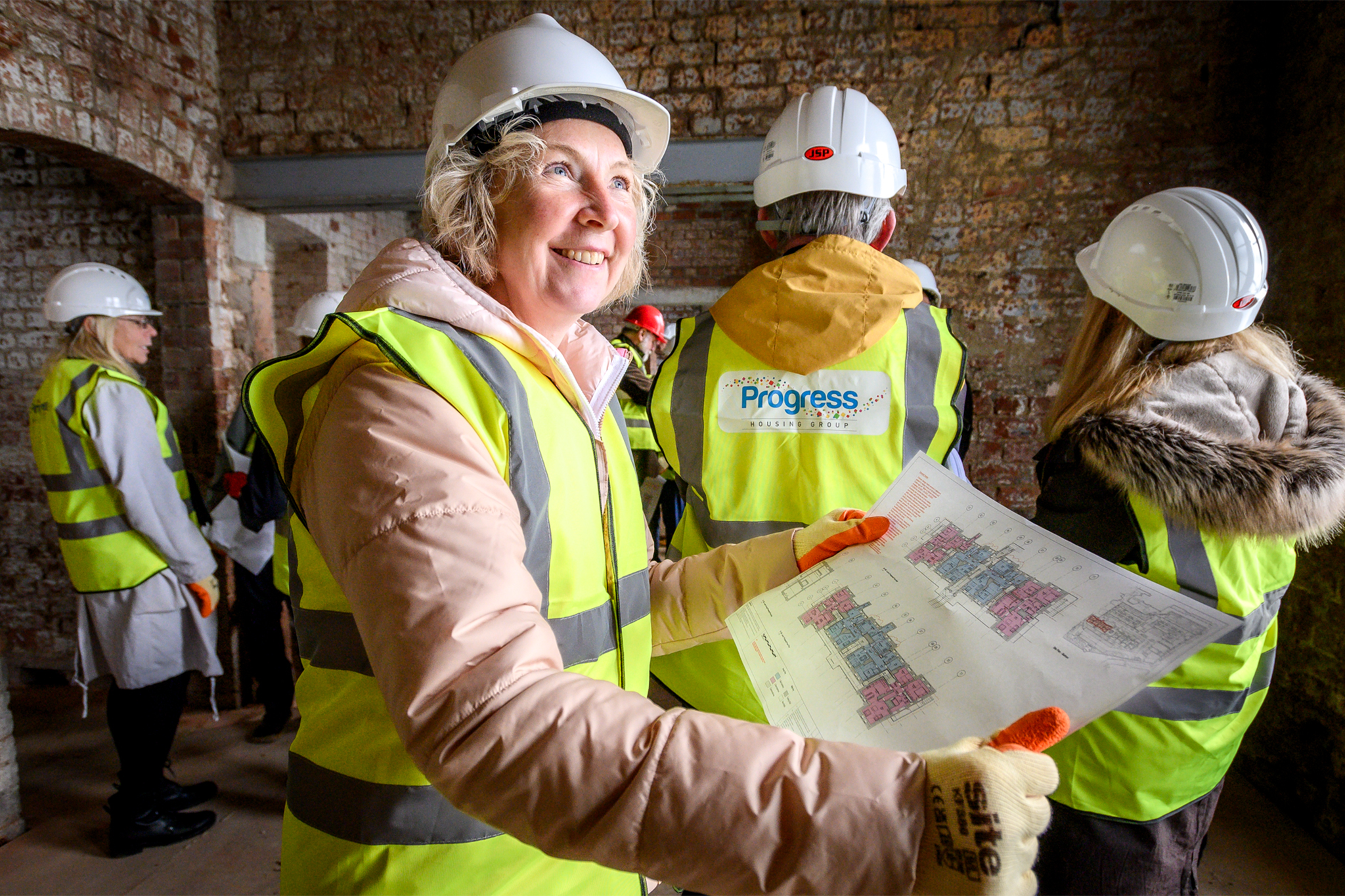Progress housing employee smiling whilst looking at floor plans