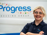 Our apprentice Alicia smiling with her arms folded in front of a progress van