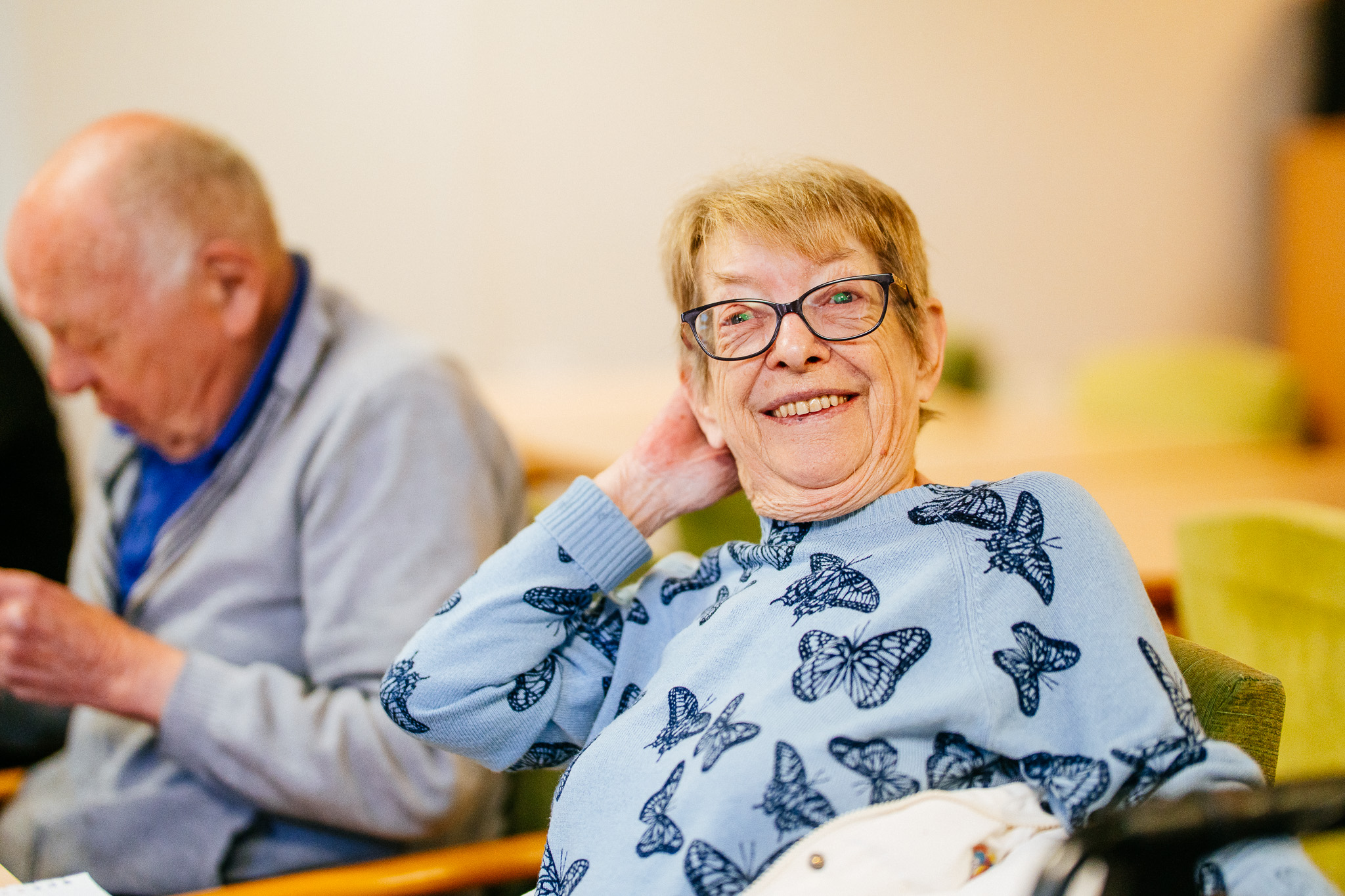 enant smiling warmly at the camera while seated indoors